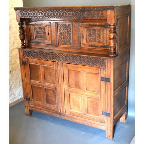 460 - A George III Oak Court Cupboard with a carved frieze above a central carving flanked by doors, the l... 