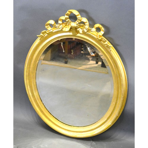 487 - A Late 19th Early 20th Century French Oval Gilded Wall Mirror with bow cresting and bevelled glass p... 