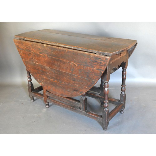 489 - *** Disposed***A George III Oak Oval Gate Leg Dining Table with a frieze drawer raised upon turned l... 