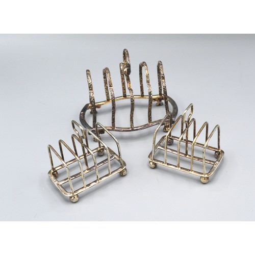 76 - A Pair of Sheffield silver miniature four division toast racks together with another similar Sheffie... 