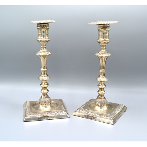 79 - A Pair of London silver candlesticks with square sconces above knopped stems and square stepped base... 