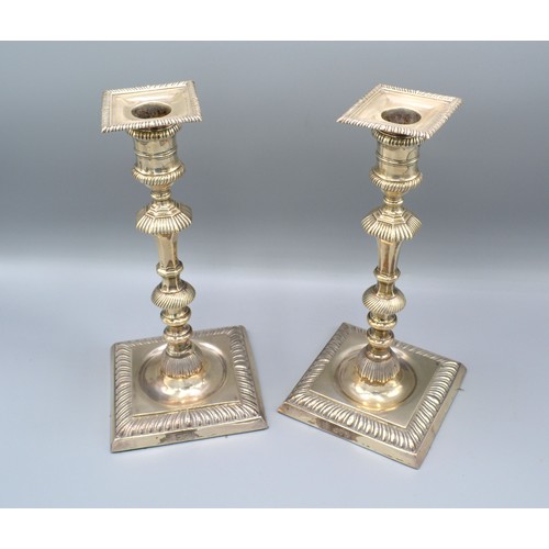 79 - A Pair of London silver candlesticks with square sconces above knopped stems and square stepped base... 