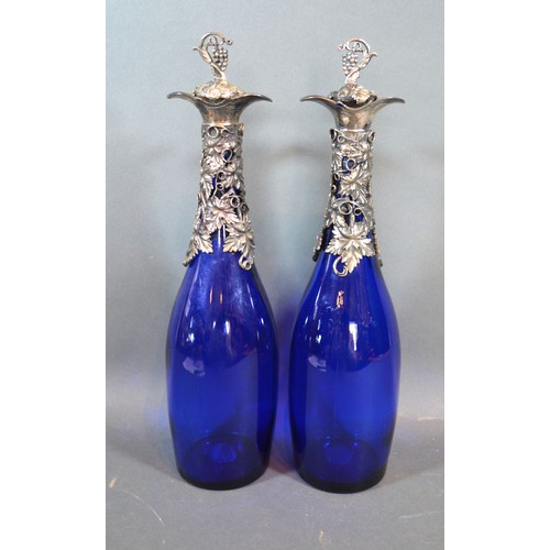 93 - A pair silver plated and blue glass decanters, decorated with grape vine, 35cms tall