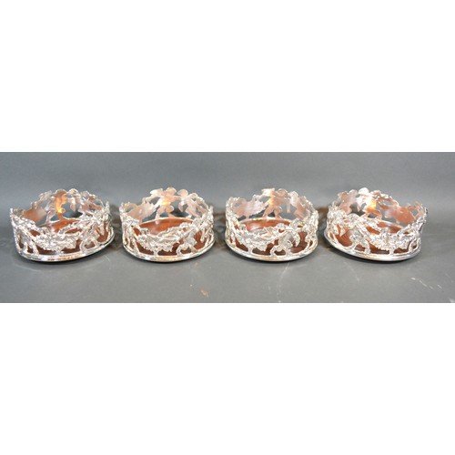 97 - A set of four silver plated bottle coasters of pierced form with cherubs amongst foliage and with tu... 