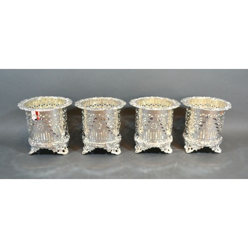 98 - A set of four silver plated bottle coasters of pierced form, each with three scroll feet, 12cms tall