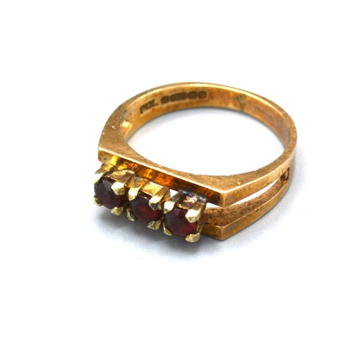 155 - A 9ct Yellow Gold Dress Ring set with three garnets within a pierced setting, 3.3 gms Size K