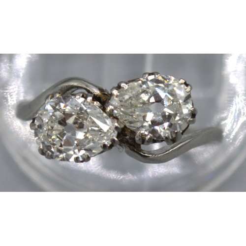 125 - A white gold diamond set crossover ring, set with two diamonds within a pierced setting, approximate... 