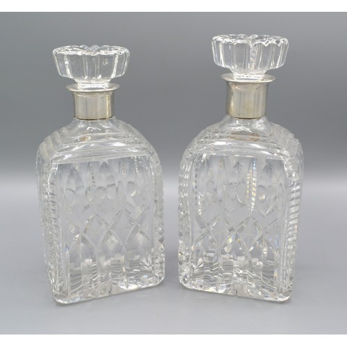 142 - A pair of 925 Sterling silver and cut glass decanters, 21cms tall