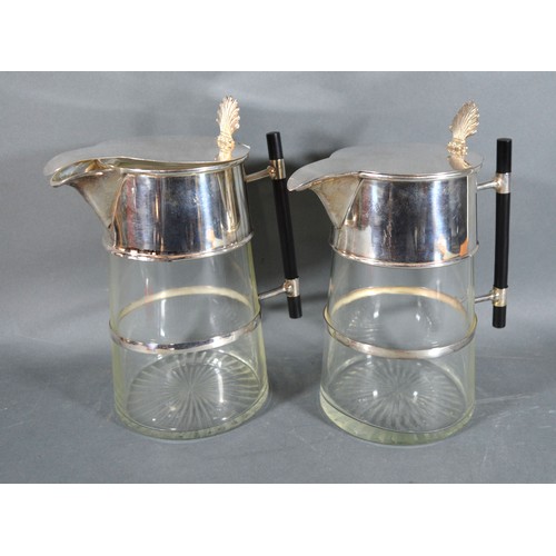 193 - A Pair of Silver Plated and Cut Glass Claret Jugs in the style of Christopher Dresser, the hinged co... 