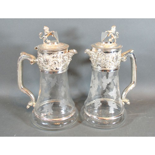 216 - A Pair of Silver Plated and Engraved Glass Claret Jugs each with lion and shield mounts with shaped ... 
