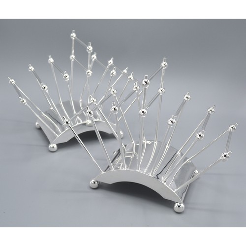 239 - In The Style Of Christopher Dresser A Pair Of Silver Plated Six Division Toast Racks 22 cms long