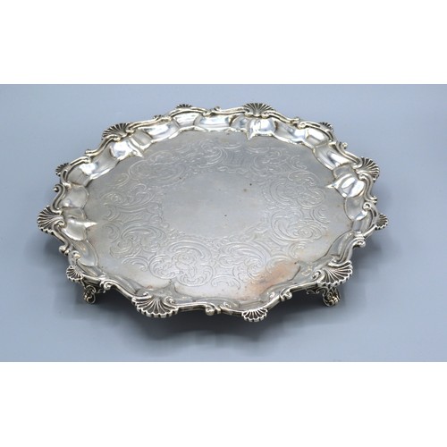 265 - A Victorian Silver Salver of shaped scallop outline with engraved decoration upon four low feet, Lon... 