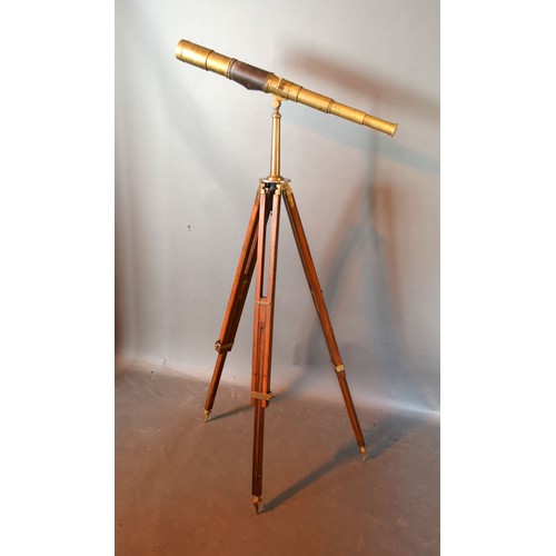 416 - A Brass And Leather Telescope with adjustable wooden and brass mounted tripod 145 cms tall