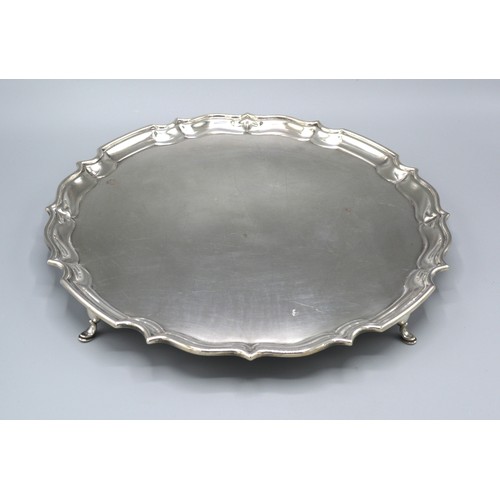 85 - A Chester Silver Salver Of Shaped Outline with four scroll feet 27 ozs. 31 cms diameter