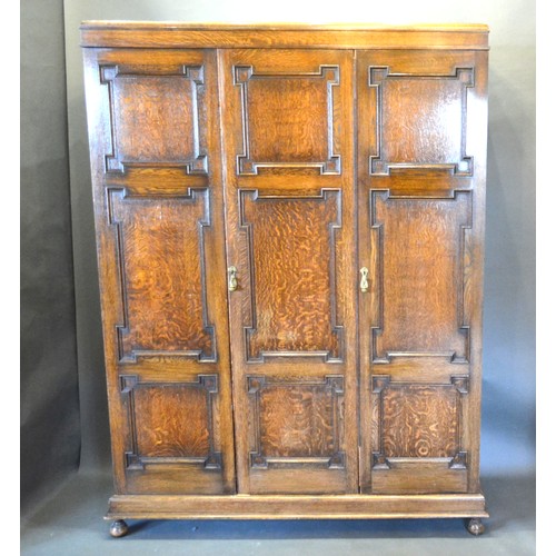 380 - An Oak Triple Wardrobe In 18th Century Style with three moulded doors raised upon low bun feet 152 c... 