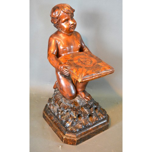 384 - A Carved Wooden figure in the form of Putti Holding A Cushion kneeling upon naturalistic base 67 cms... 