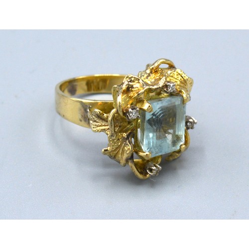 136 - A Yellow Metal Dress Ring set with a rectangular aquamarine and four diamonds within a pierced setti... 