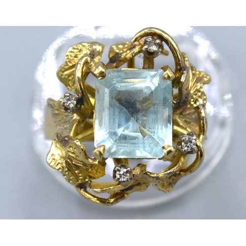 136 - A Yellow Metal Dress Ring set with a rectangular aquamarine and four diamonds within a pierced setti... 