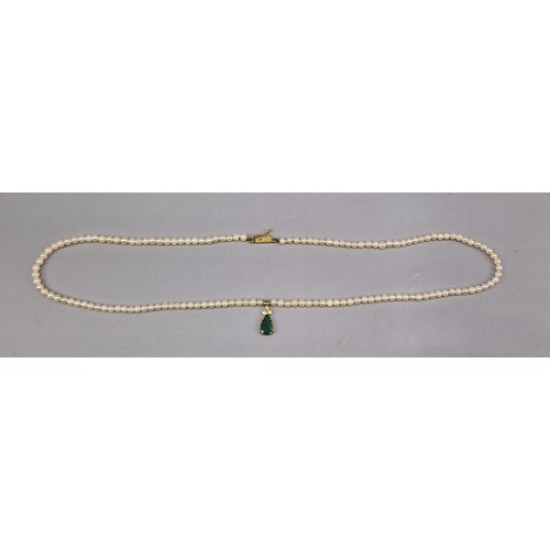 476 - A cultured pearl necklace with 18ct gold diamond and emerald set teardrop pendant, 46cms long