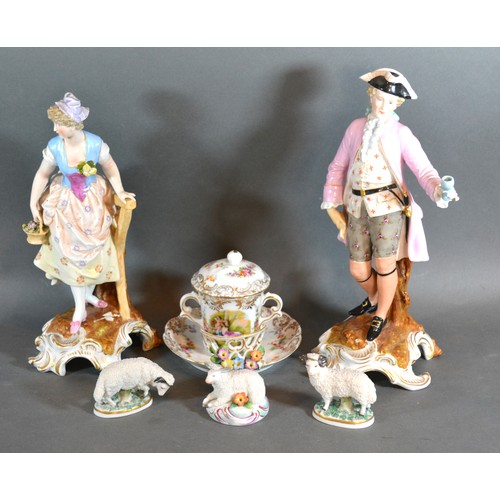 23 - A pair of porcelain continental figures together with a chocolate cup saucer and cover and three mod... 