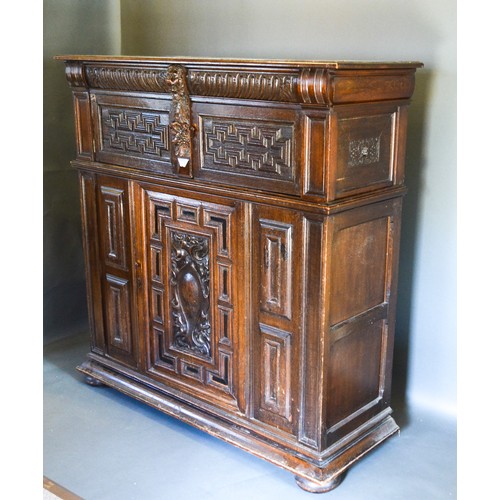 309 - An Oak Court Cupboard with two moulded doors above a central moulded and carved door, raised upon lo... 