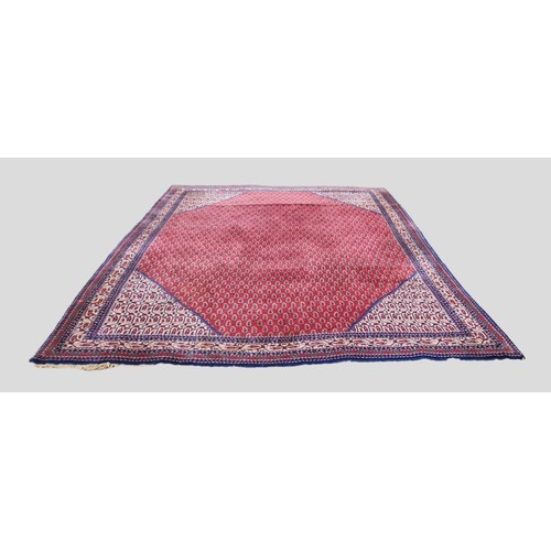 290 - A North West Persian Woollen Carpet with an all over design upon a red, blue and cream ground within... 