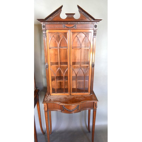 353 - A Pair Of Mahogany Sheraton Revival Cabinets On Stands each with a moulded pediment above arched, gl... 