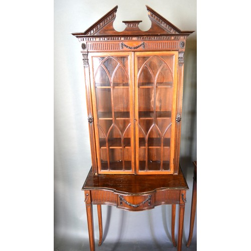 353 - A Pair Of Mahogany Sheraton Revival Cabinets On Stands each with a moulded pediment above arched, gl... 