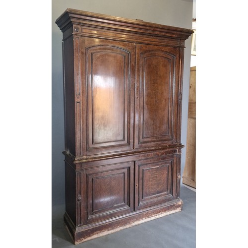 349 - A 19th Century oak library bookcase, the moulded cornice above two arched panel doors, the lower sec... 