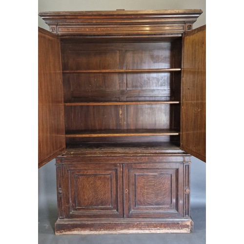 349 - A 19th Century oak library bookcase, the moulded cornice above two arched panel doors, the lower sec... 