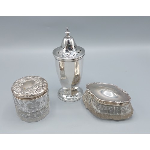 126 - A silver sugar sifter, (marks rubbed) together with two silver topped dressing table bottles