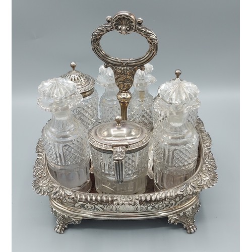 148 - A George III silver cruet set comprising seven cut glass bottles, three with silver mounts, the stan... 