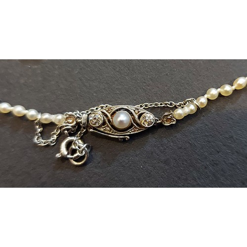 233 - A natural and cultured pearl necklace, the white metal clasp set with diamonds and central pearl, co... 