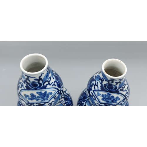 1 - A pair of Chinese porcelain double gourd vases, each decorated in underglaze blue and with four char... 