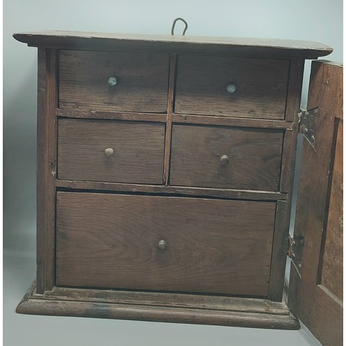 458 - An oak Spice cabinet with a panel door enclosing drawers, 41cms wide, 39cms tall