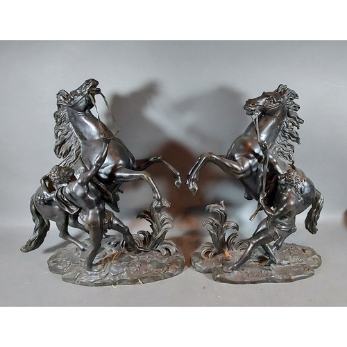 304 - After Guillaume Coustou, a pair of patinated bronze Marly horse groups, 40cms tall