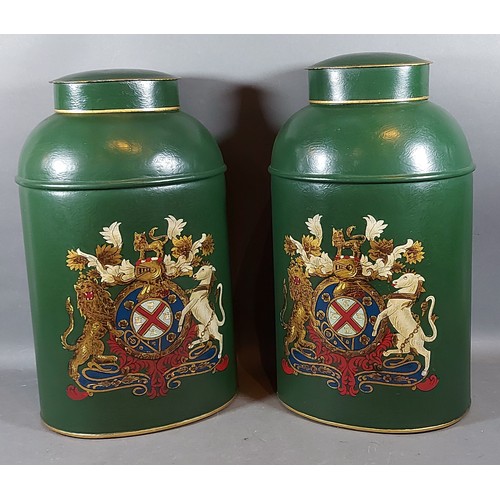 309 - A pair of toleware cannisters each decorated with a crest upon a green ground, 45cms tall