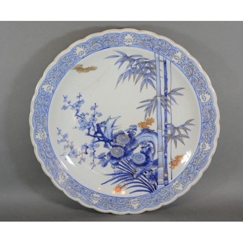 55 - A Japanese porcelain charger decorated in under glaze blue and highlighted with gilt, 41cms diameter