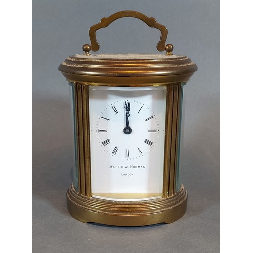 320 - An oval brass carriage clock by Matthew Norman wthe lever escapement, 12cms tall