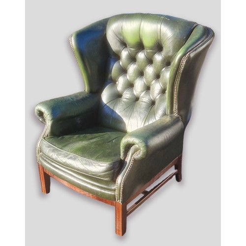 357 - A green leather button upholstered wingback armchair with square legs and stretchers