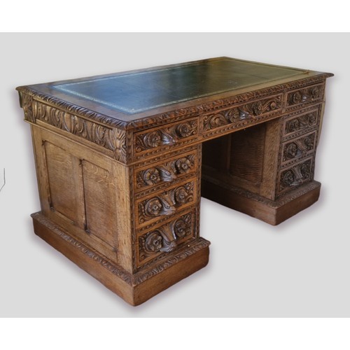 358 - A Victorian carved oak twin pedestal desk, the tooled leather inset top above nine drawers with mask... 