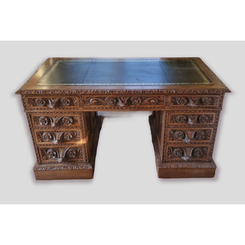 358 - A Victorian carved oak twin pedestal desk, the tooled leather inset top above nine drawers with mask... 