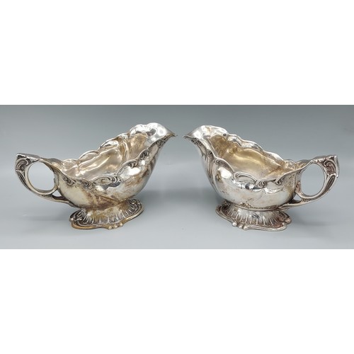 155 - A pair of 830 silver sauce jugs of shaped form, 18ozs