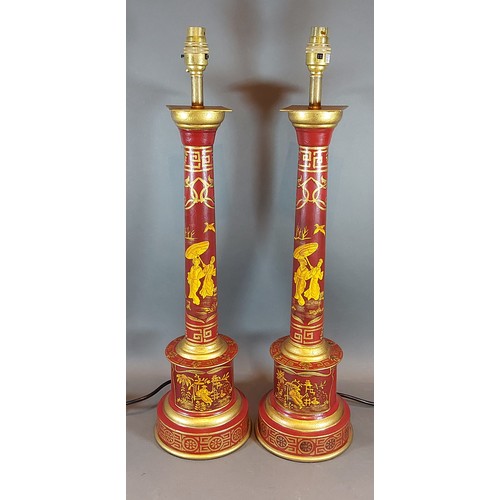 282 - A pair of Toleware table lamps, each with gilded decoration upon a red ground, 60cms tall