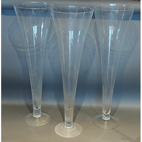 15 - A set of three large glass spill vases of tapering form, 80cms tall