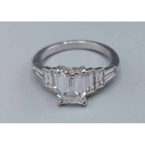 172 - A Platinum diamond ring, the central 2.12ct Emerald cut diamond flanked by baguette diamonds complet... 