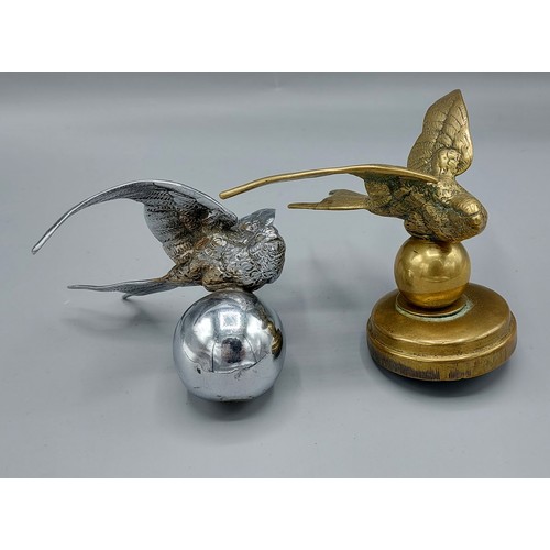 308 - A brass car mascot in the form of a bird together with another similar