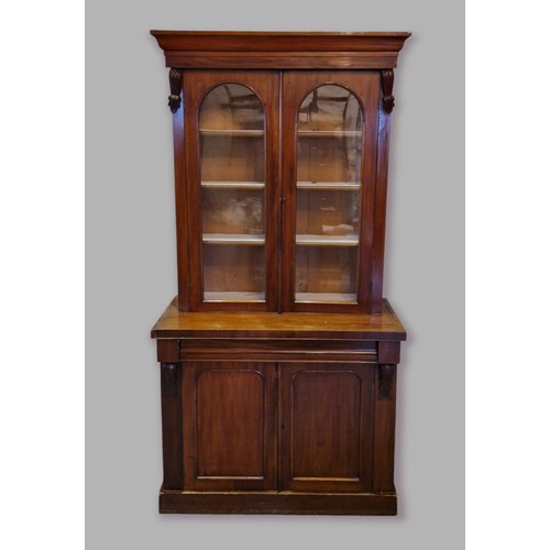 385 - A Victorian mahogany bookcase, the moulded cornice above two glazed doors enclosing shelves, the low... 