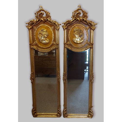 387 - A pair of gilt framed rectangular wall mirrors each with a pierced scroll cresting above a panel dec... 