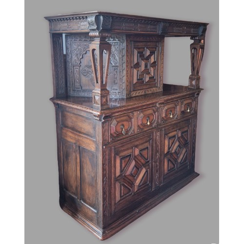 388 - An oak Court Cupboard, the top with a central moulded door flanked by pierced column, the lower sect... 